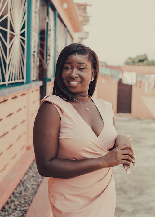 Young Elegant Woman Standing near a Building and Smiling 