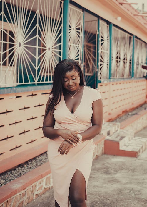 Young Woman in a Dress Standing on a Sidewalk 