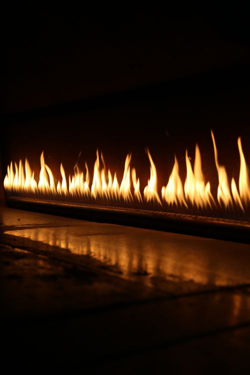 Free Captivating close-up of flames dancing against a dark background, illustrating warmth and intensity. Stock Photo