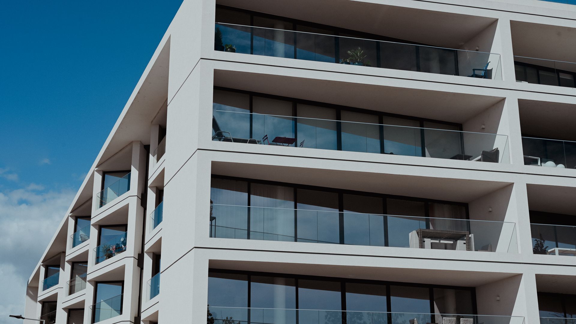 Contemporary apartment building in Faro, featuring sleek balconies and clear blue skies — tenancy by the entirety