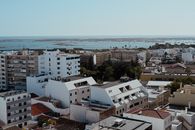 Overlooking the urban landscape of Faro, Portugal, with a glimpse of the distant Atlantic Ocean.