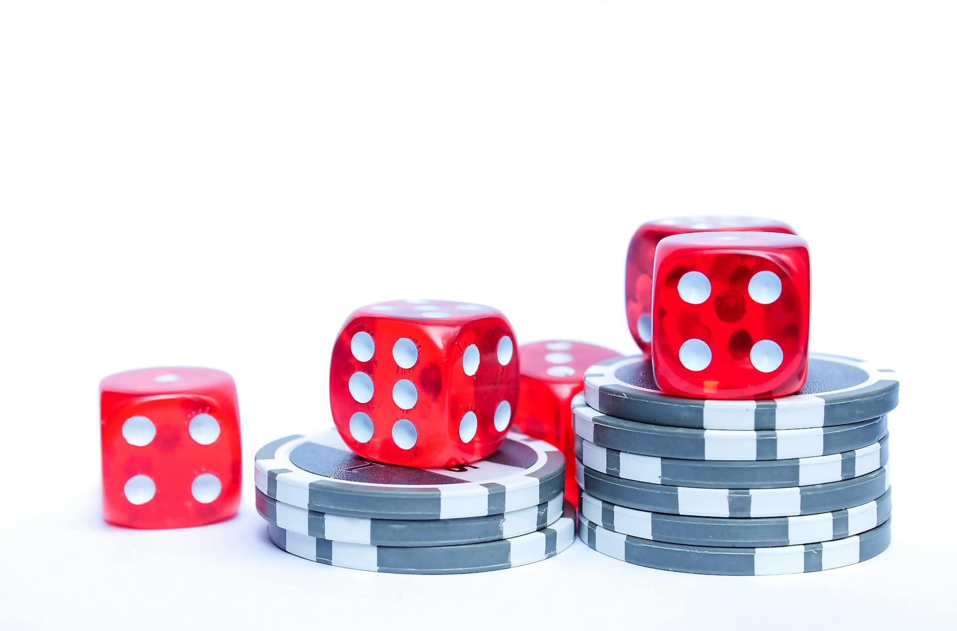 Vibrant red dice stacked with poker chips, ideal for gambling themes.