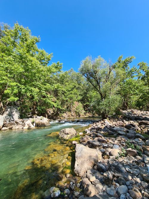 Free Crystal clear river flowing through lush greenery and rocks in Antalya, Turkey. Stock Photo