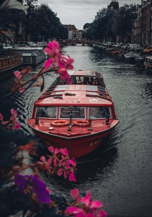 A Red Boat in the Canal in Amsterdam, the Netherlands 