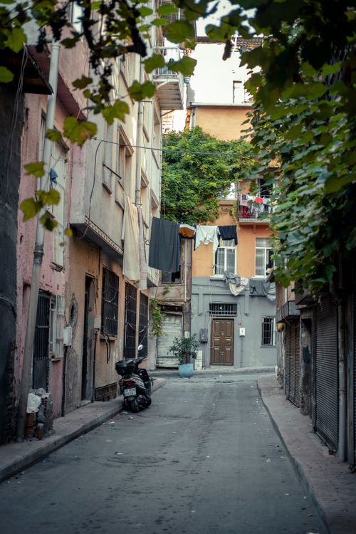 Free A quaint urban alley with hanging laundry, capturing the essence of city living in a residential district. Stock Photo