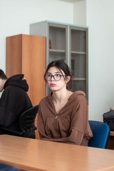 Young student attentively listening in a classroom environment.