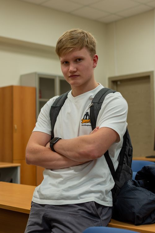 Free Confident teenage student standing with arms crossed in a classroom setting. Stock Photo