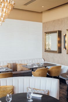 Stylish dining area with modern decor, featuring empty tables set for guests in a chic restaurant.