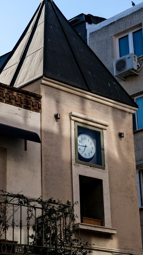 Free A close-up view of a classical urban building with a clock tower and architectural details. Stock Photo