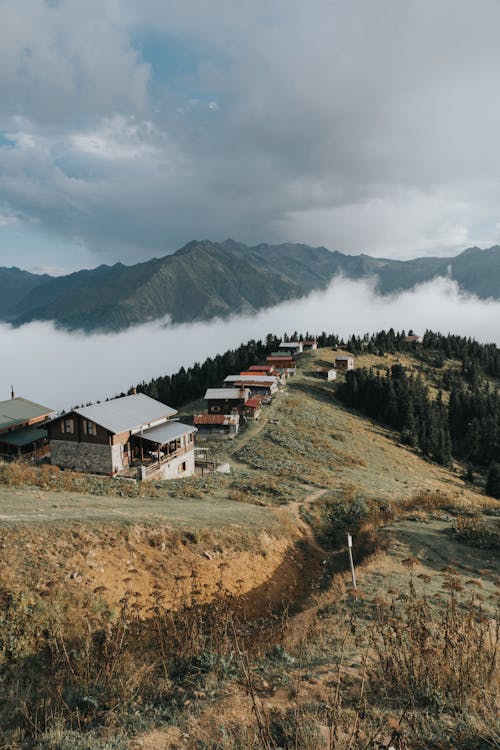Cloud behind Village on Hill in Mountains