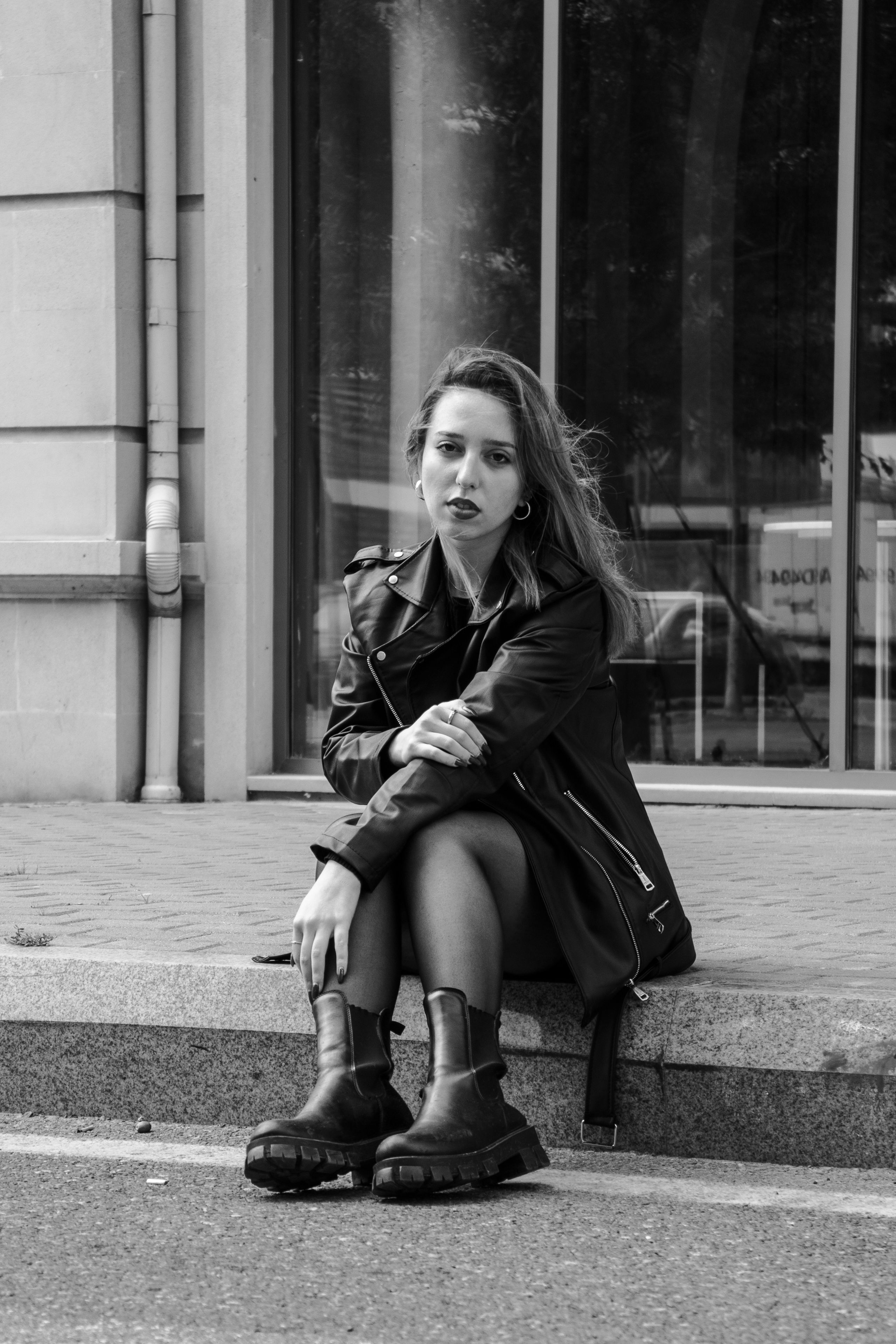woman in graphic tee and black moto jacket with ankle booties