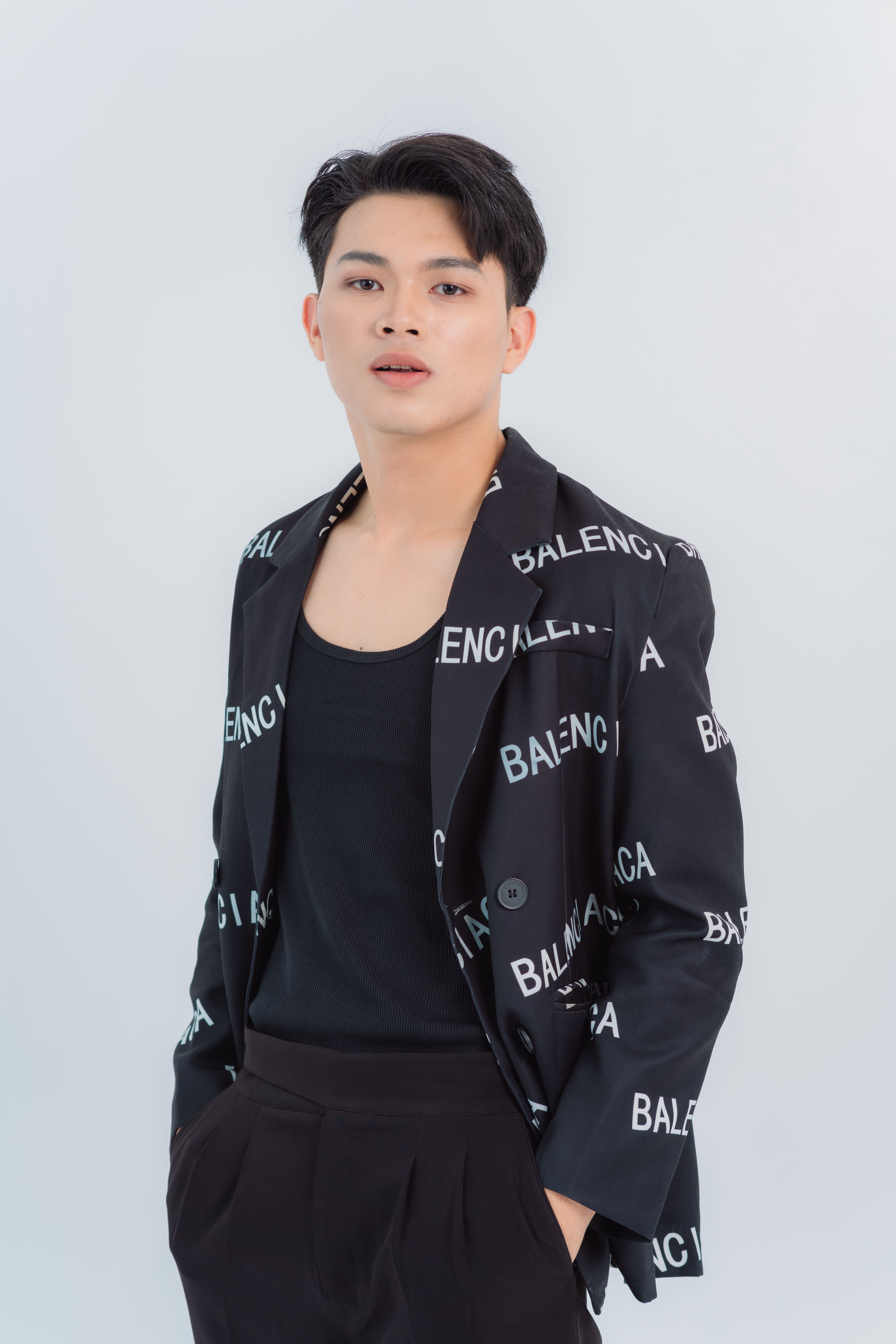 Portrait of a young man posing confidently in a designer jacket.