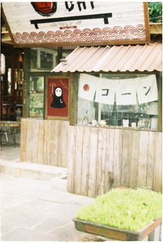 Charming rustic wooden stall in an outdoor coffee shop featuring unique decor and greenery.