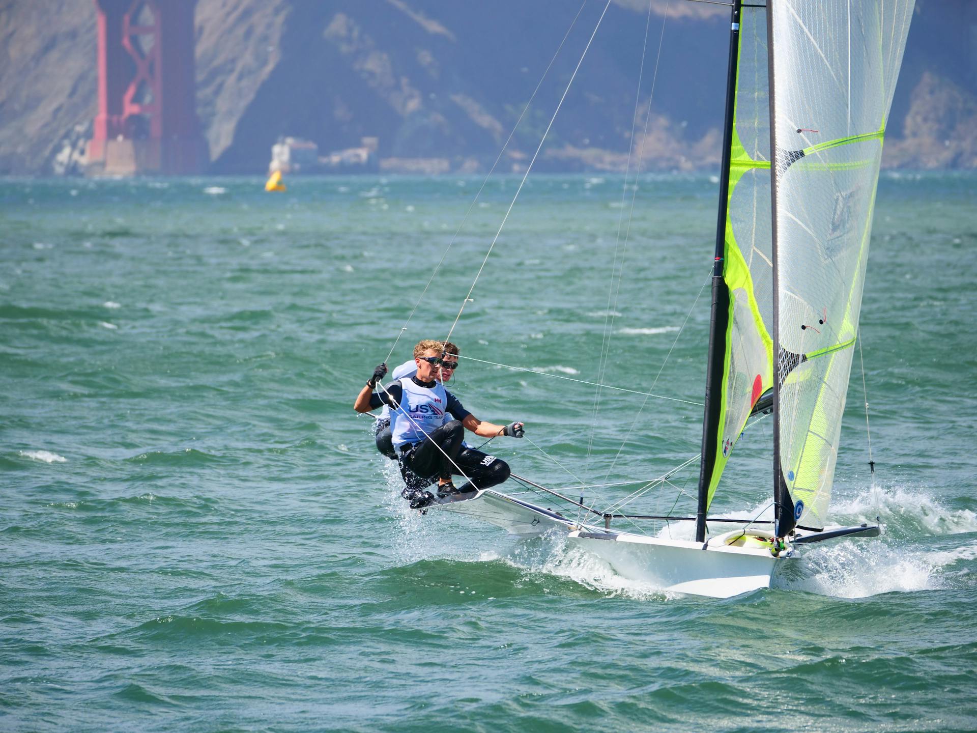 Dynamic sailing action against the backdrop of San Francisco's iconic Golden Gate Bridge.