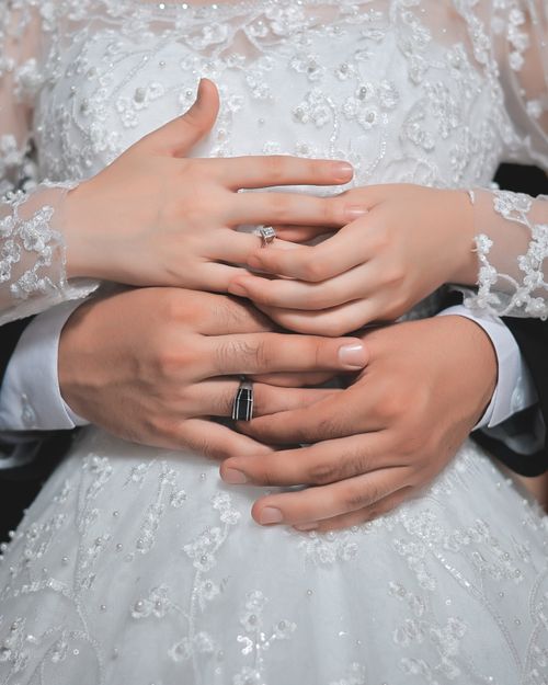 Free Romantic embrace of a couple wearing wedding rings, showcasing love and intimacy. Stock Photo
