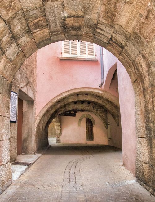 Free Explore a picturesque alleyway with ancient stone arches in a historic old town. Stock Photo