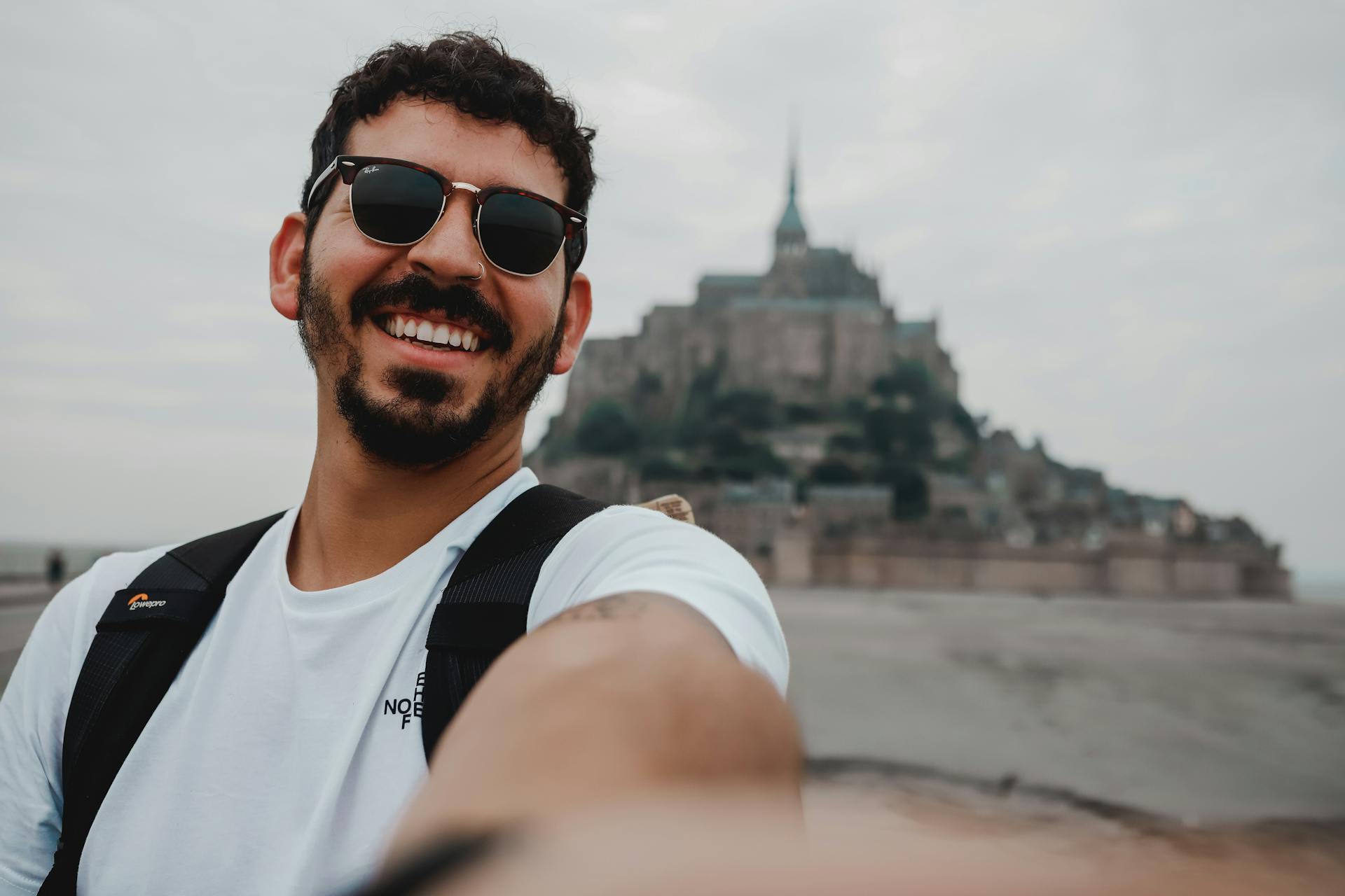 Cheerful Man Taking Selfie with Mount Saint Michel