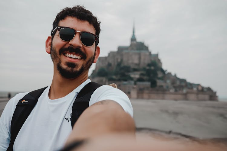 Cheerful Man Taking Selfie With Mount Saint Michel 