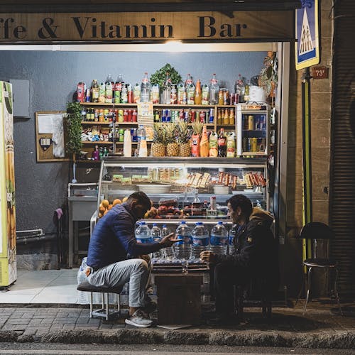 Two People Playing Board Games Outside Cafe and Vitamin Bar
