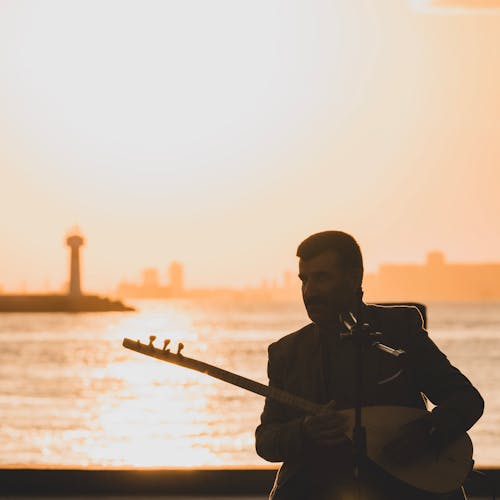 Silhouette of Man Playing on Banjo