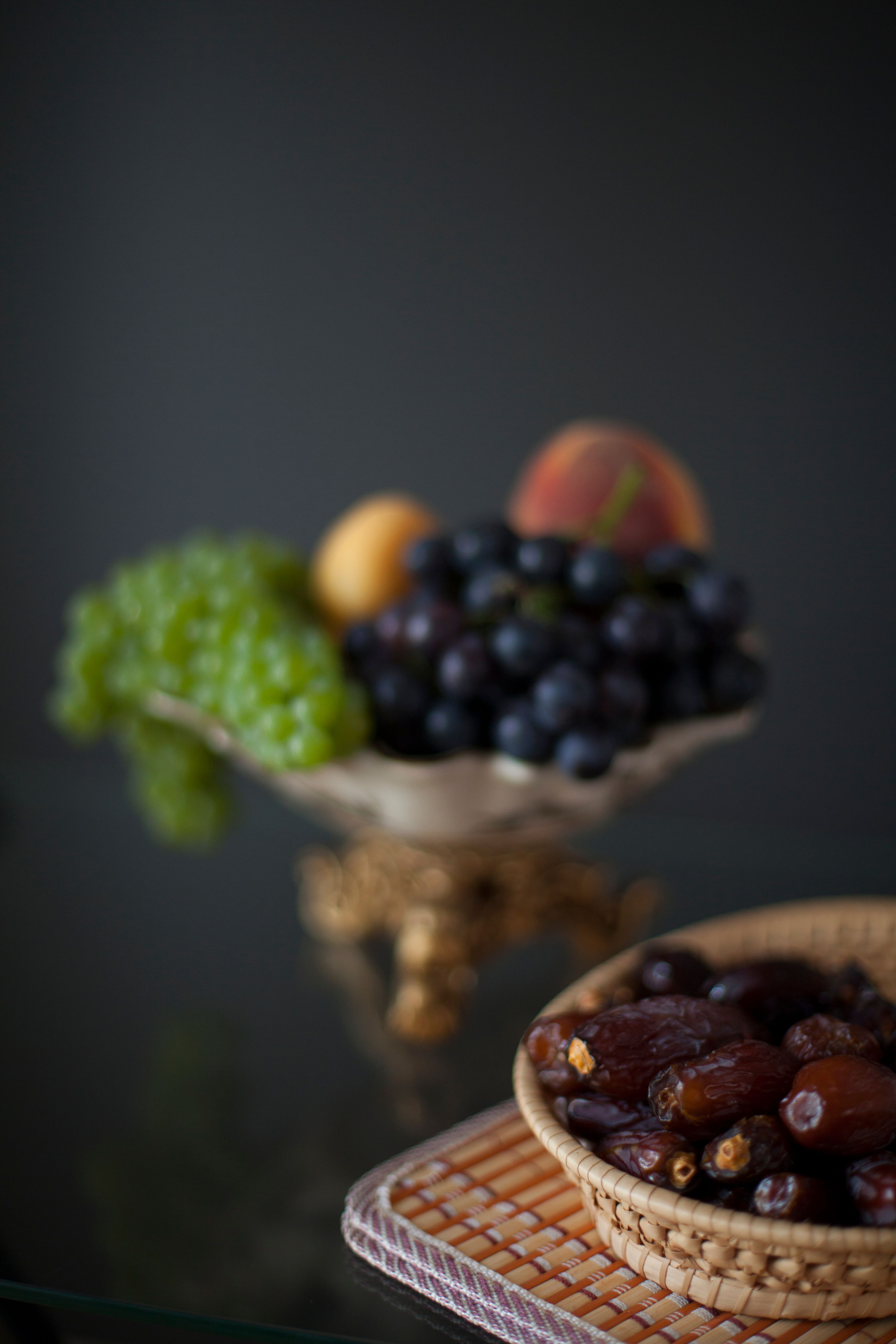 Artistic still life of dates, grapes, and other fruits in soft lighting. Perfect for Ramadan themes.