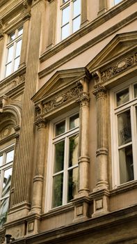 Detailed view of a classic building facade highlighting ornate architectural features and windows.