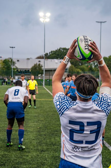Rugby player in action during a match, ready to throw the ball.
