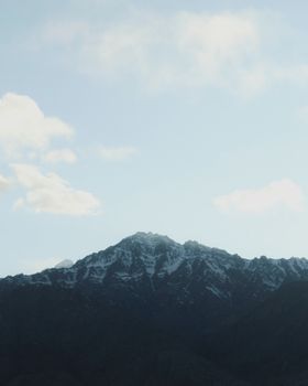 Breathtaking view of snow-capped mountain peaks against a clear blue sky, perfect for winter or travel themes.