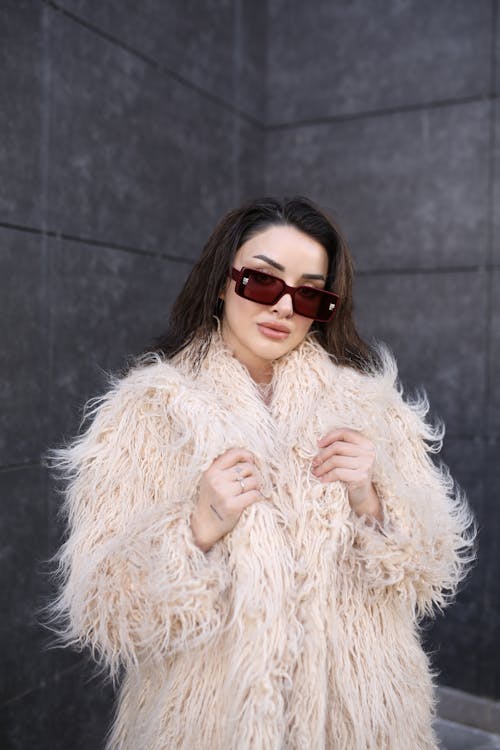 Free Young Brunette Woman in Sunglasses Posing in a Fur Coat Stock Photo