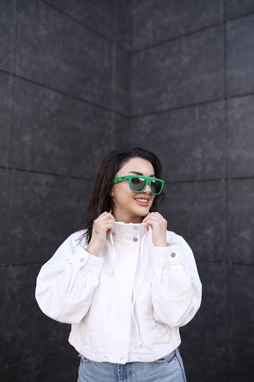 Smiling Woman in Sunglasses Posing in a Jacket