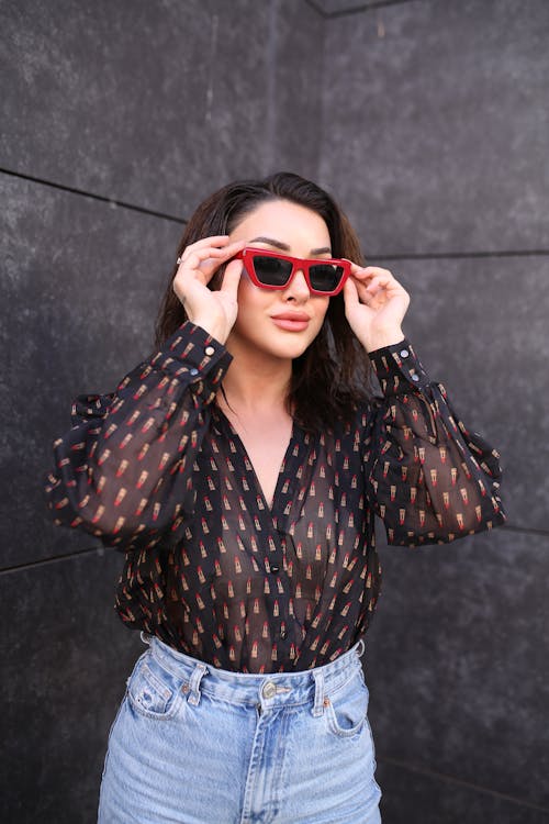 Young Brunette Woman Holding her Red Sunglasses