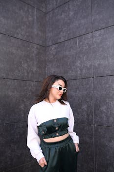 Fashionable young woman in stylish outfit posing outdoors with elegance and flair.