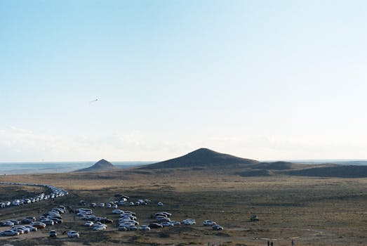 Scenic view of a long line of cars in a vast desert landscape under a clear sky.