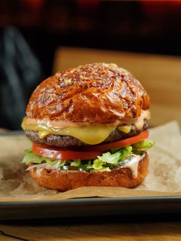 Mouthwatering cheeseburger with lettuce, tomato, and cheese, perfect for indulging.