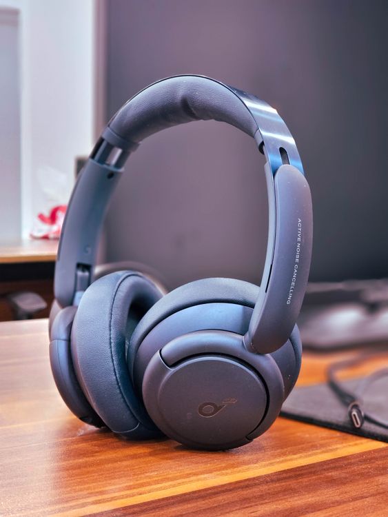 Bežične noise cancelling slušalice na drvenom stolu