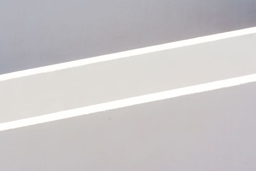 A minimalist abstract photo showcasing light and shadow on a textured surface.