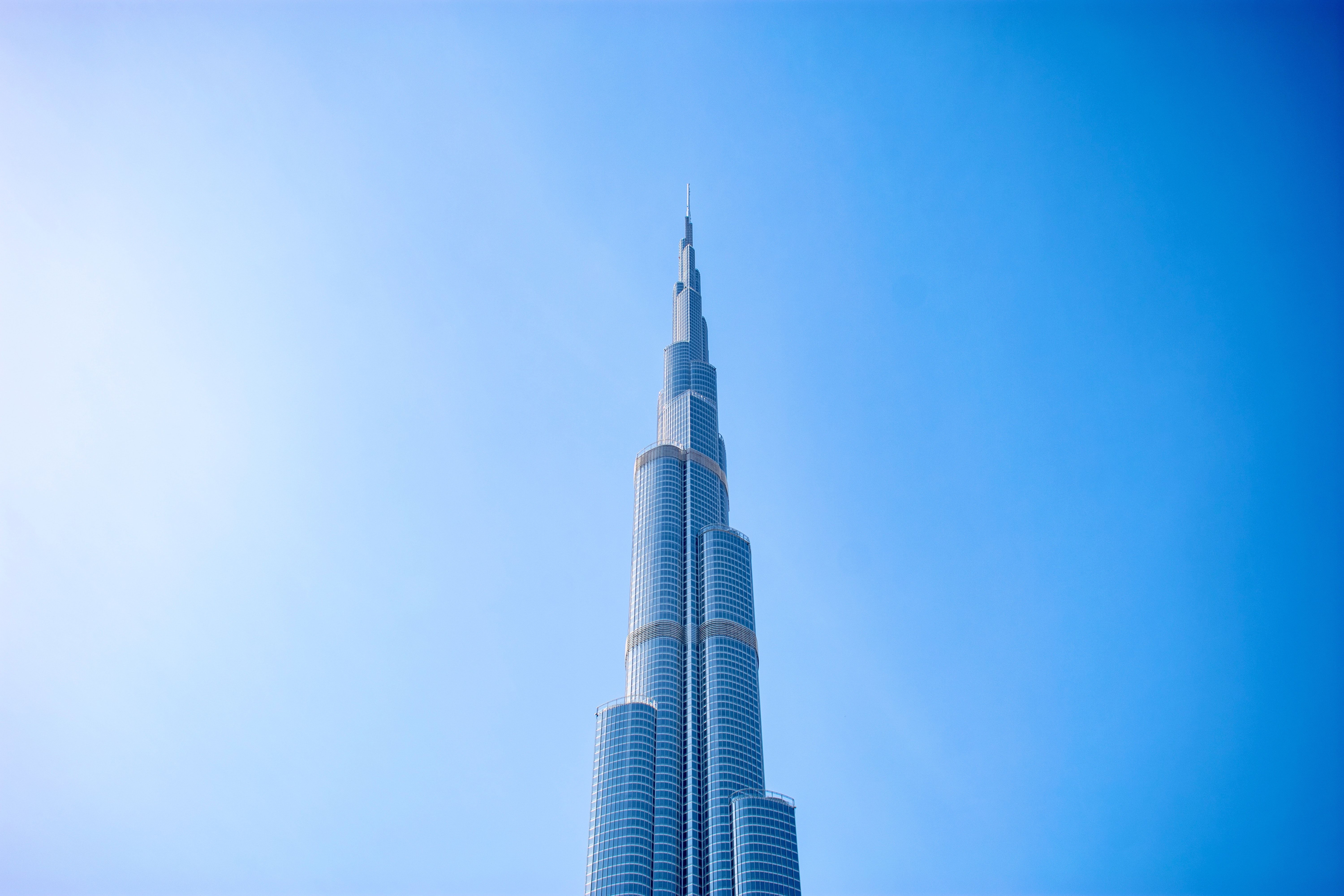 High angle shot of Burj Khalifa, Dubai with a clear blue sky backdrop, showcasing modern architectur