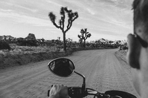 Man Riding a Motorbike on a Desert in Black and White 