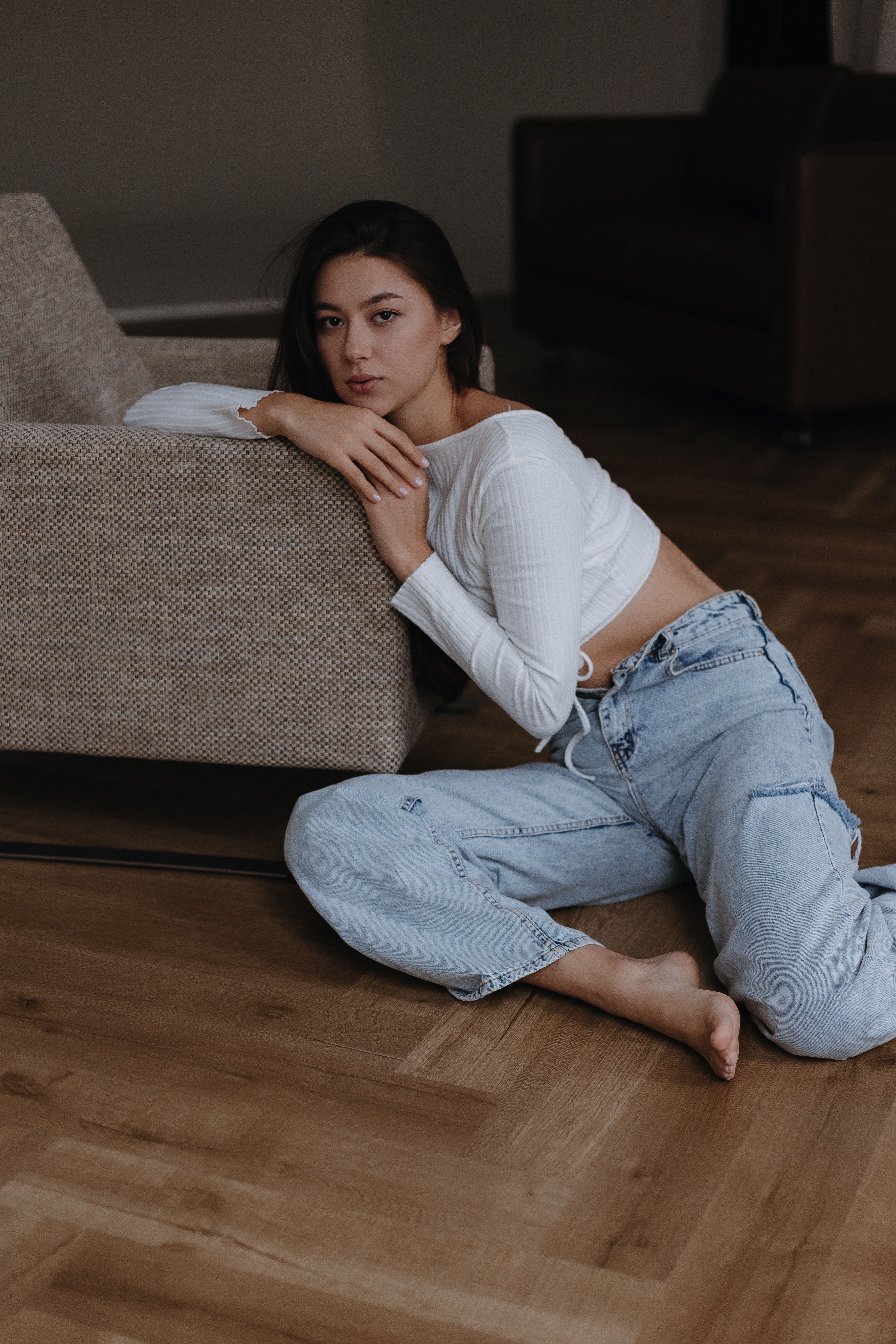 Woman in White Long Sleeve Shirt and Blue Denim Jeans Sitting on Brown ...