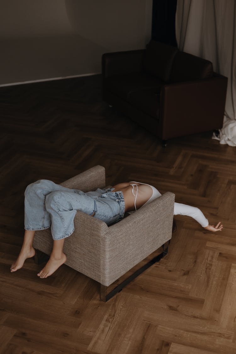 Woman In Jeans Lying On Chair