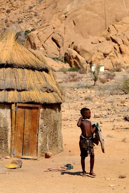 Boy from African Tribal Village in Front of Hut