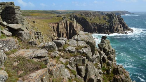 Free Scenic view of rocky cliffs and vibrant sea at Land's End, Cornwall. Stock Photo