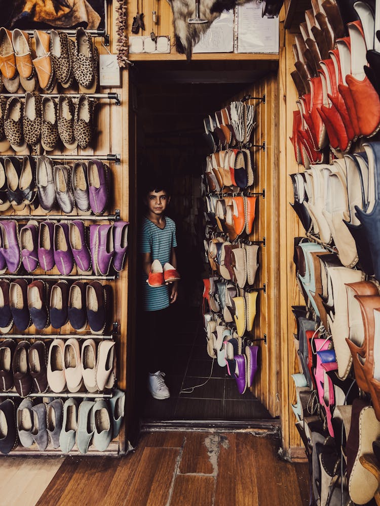 Boy Walking Into Room Lined With Shoes