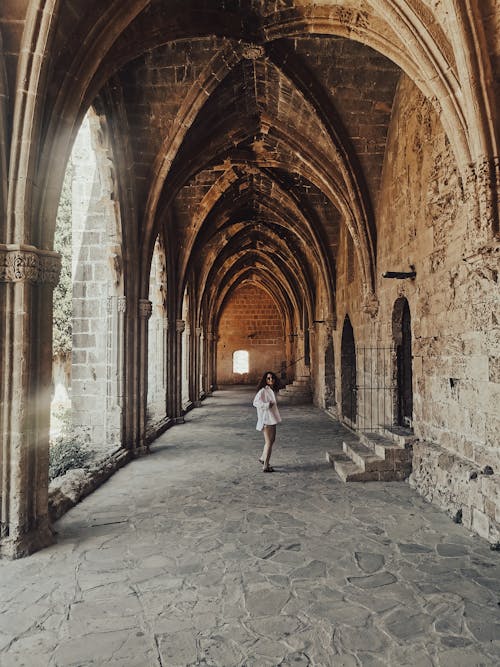 Woman Standing in Hallway of Gothic Castle