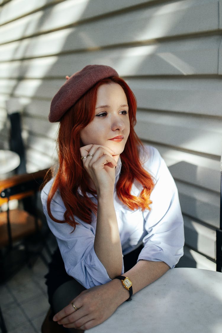 Portrait Of A Pretty Redhead Sitting Outdoors