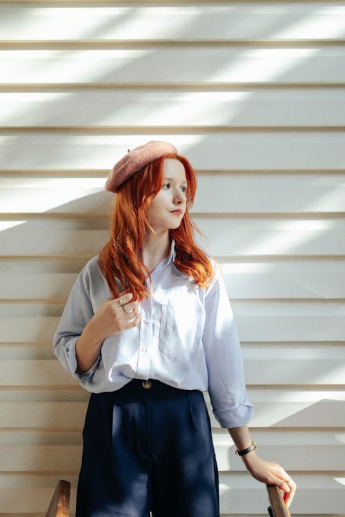 Free Portrait of a Female Model Wearing a Beret Standing against a White Wall Stock Photo