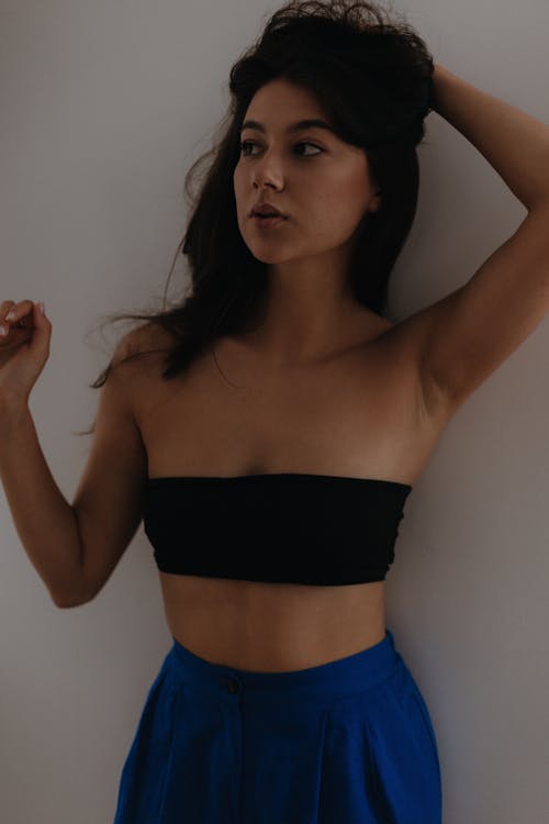 Young Brunette Woman Posing in Black Bandeau Top and Blue Pants