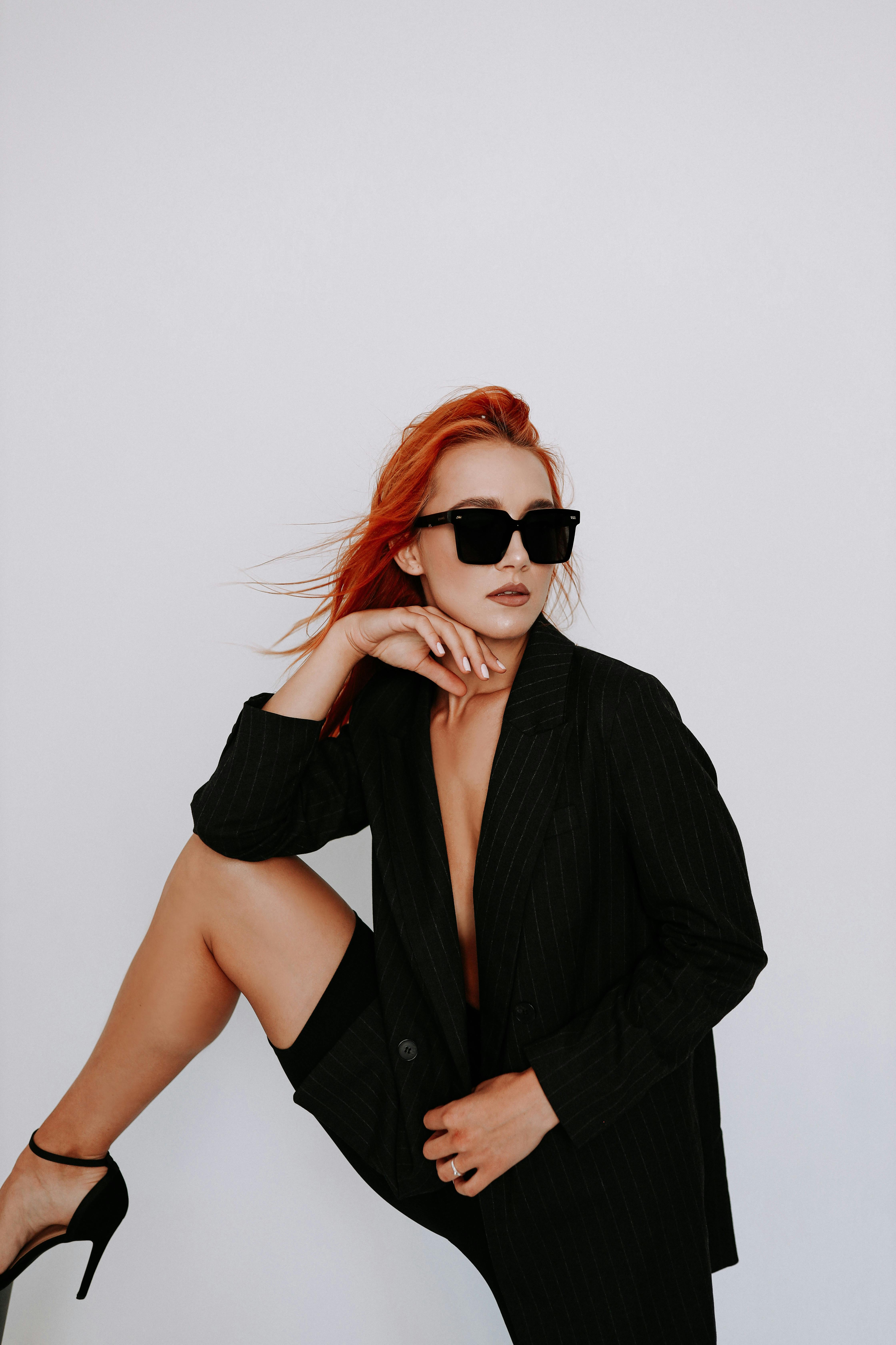 Elegant redhead woman in a black jacket and high heels exudes confidence and style, Irpin, Ukraine.