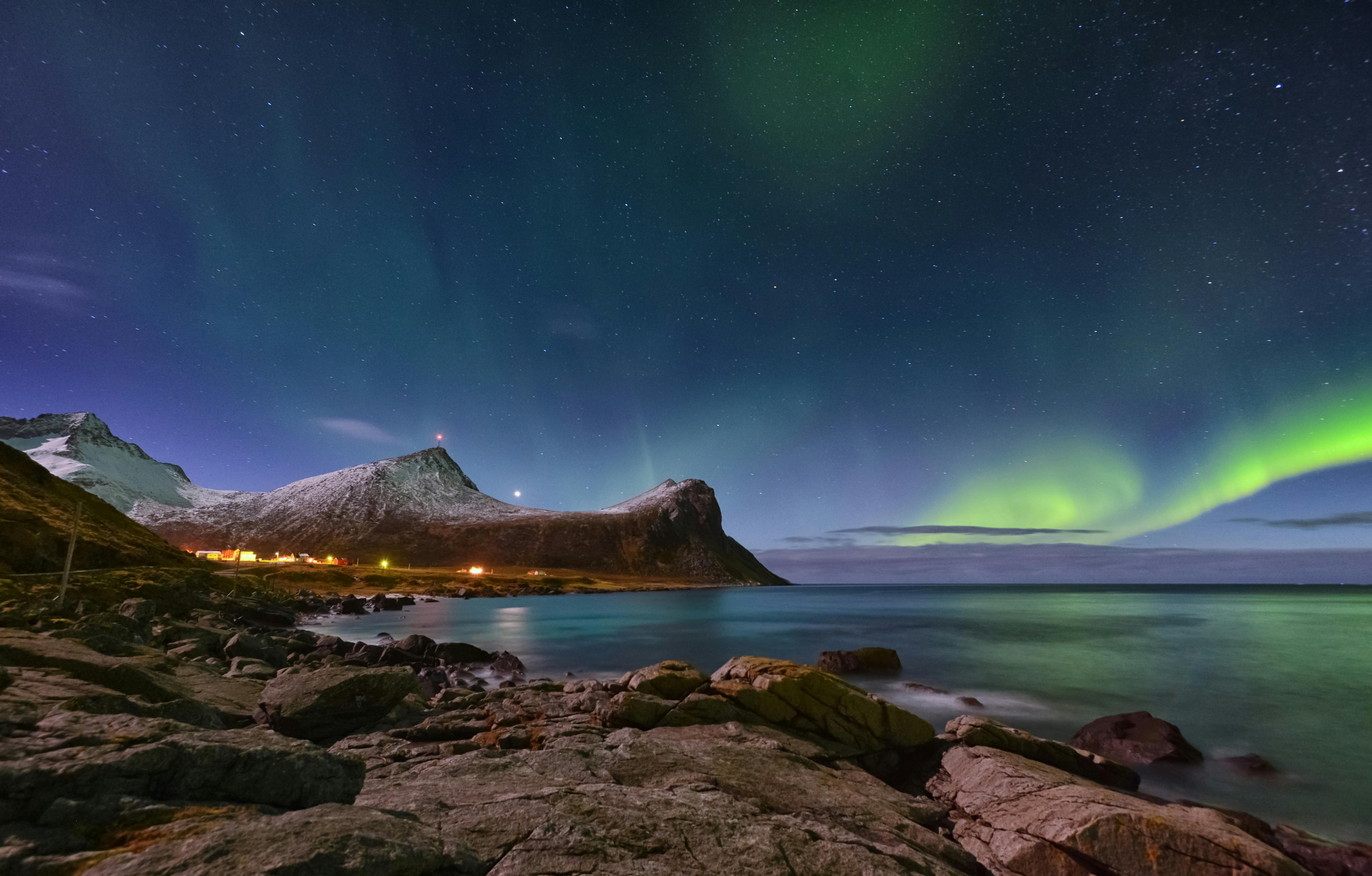 Prescription Goggle Inserts - Stunning aurora borealis over Myrland, Norway, with rocky coast and starry sky.