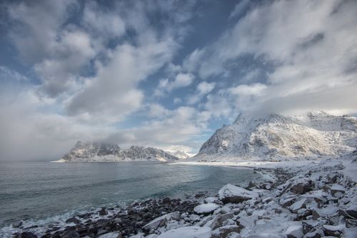 Free Breathtaking view of snowy mountains and icy coast in Lofoten, Norway, showcasing winter serenity. Stock Photo